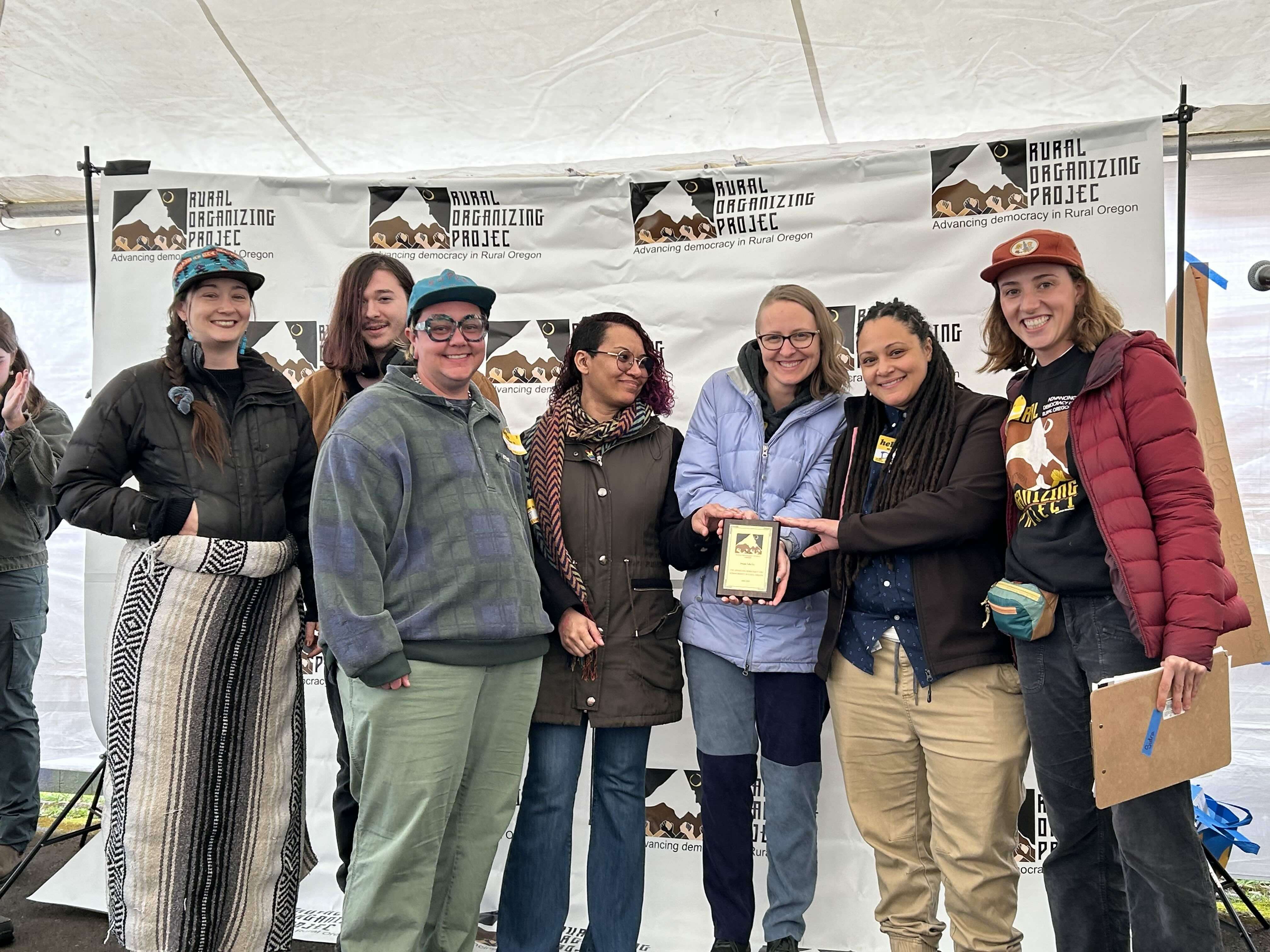 7 people pose for a photo holding their Human Dignity Award.