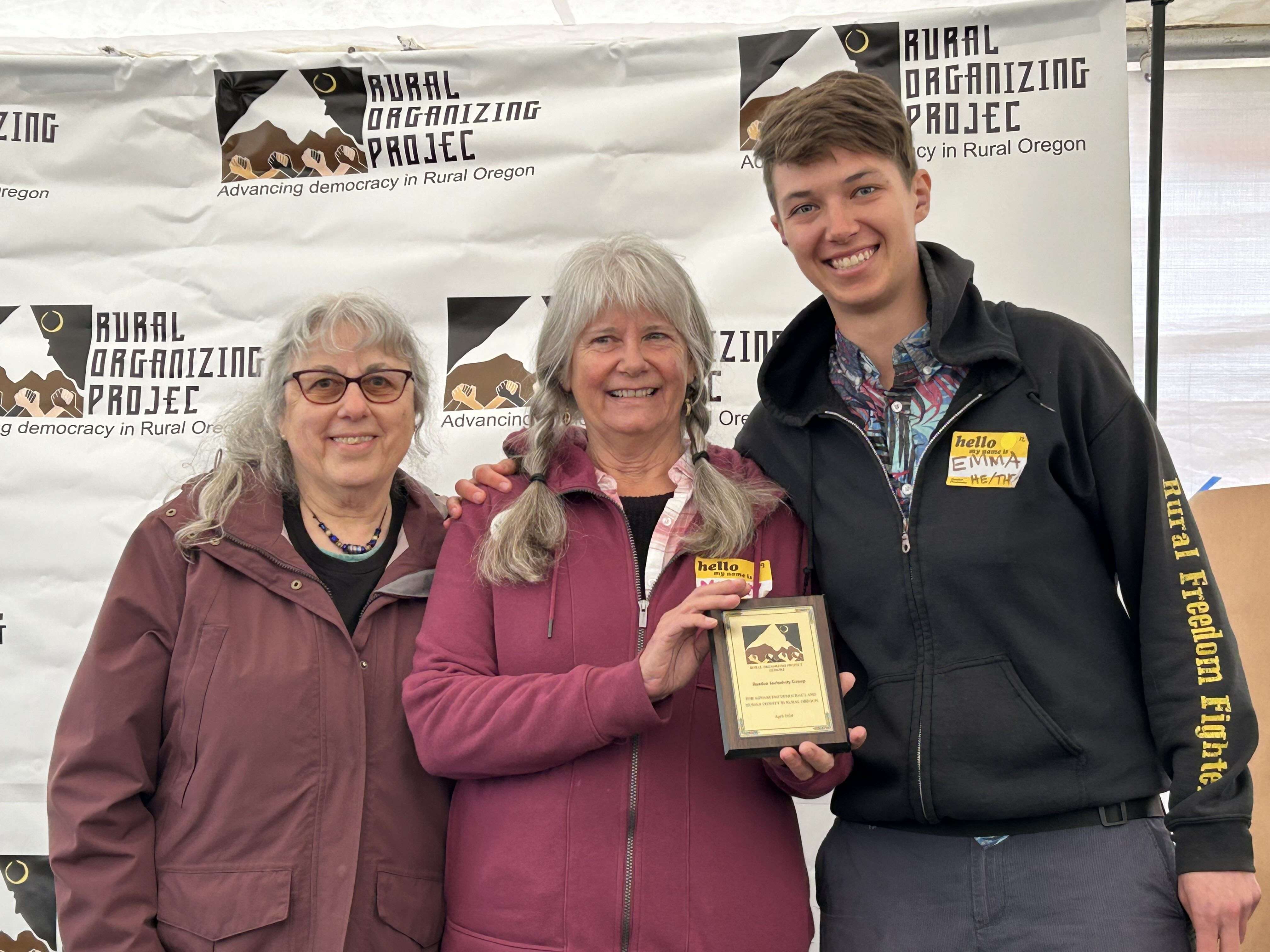3 people pose for a photo holding their Human Dignity Award.