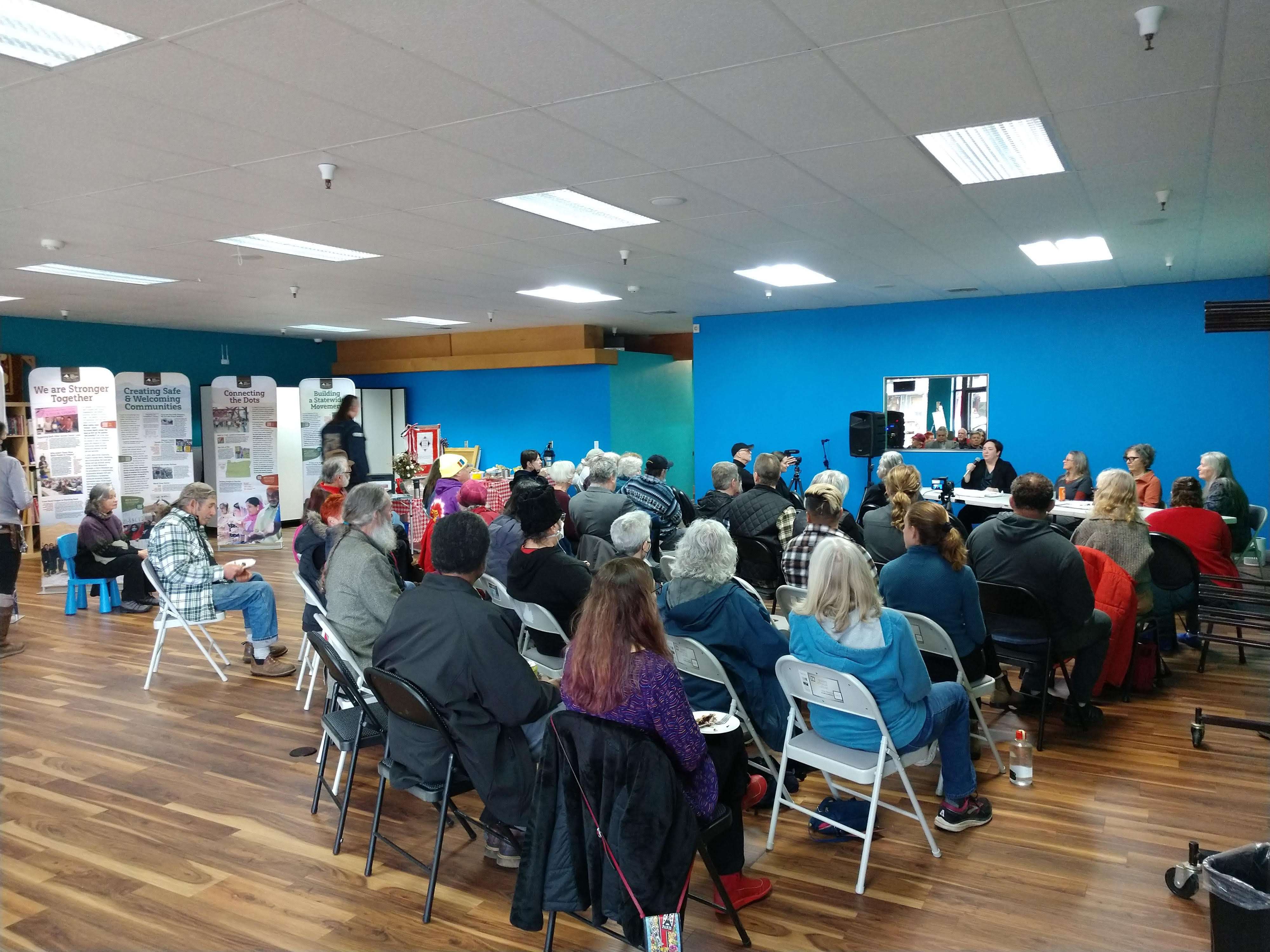 50 personas sentadas escuchando un panel.