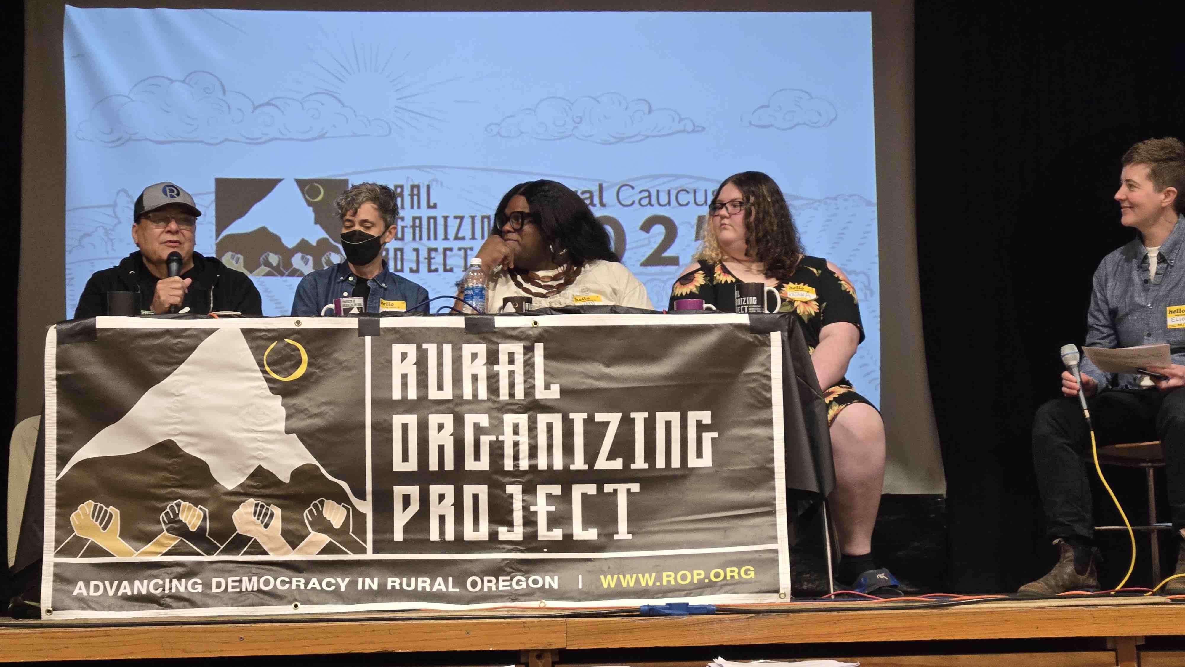 A panel of human dignity leaders speak with each other seated behind an ROP banner.